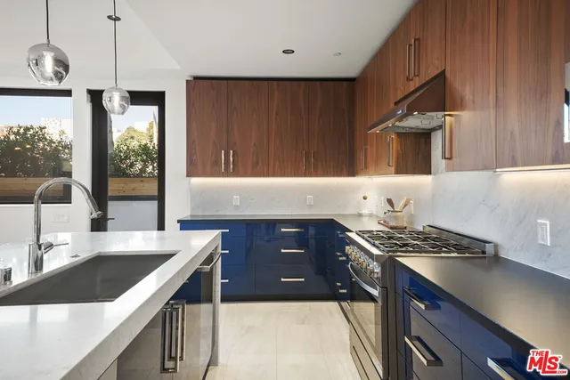 a kitchen with granite countertop a sink stove and cabinets