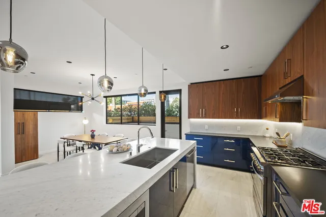 a kitchen with stainless steel appliances granite countertop a sink a stove and a refrigerator