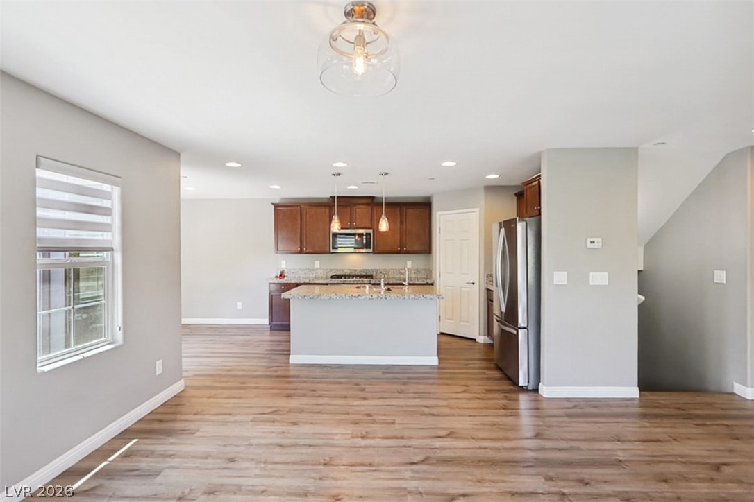 9940 Sable Point Street Las Vegas, NV 89178 - Photo 15 of 40 Kitchen featuring stainless steel appliances, recessed lighting, light wood-style flooring, baseboards, and decorative light fixtures