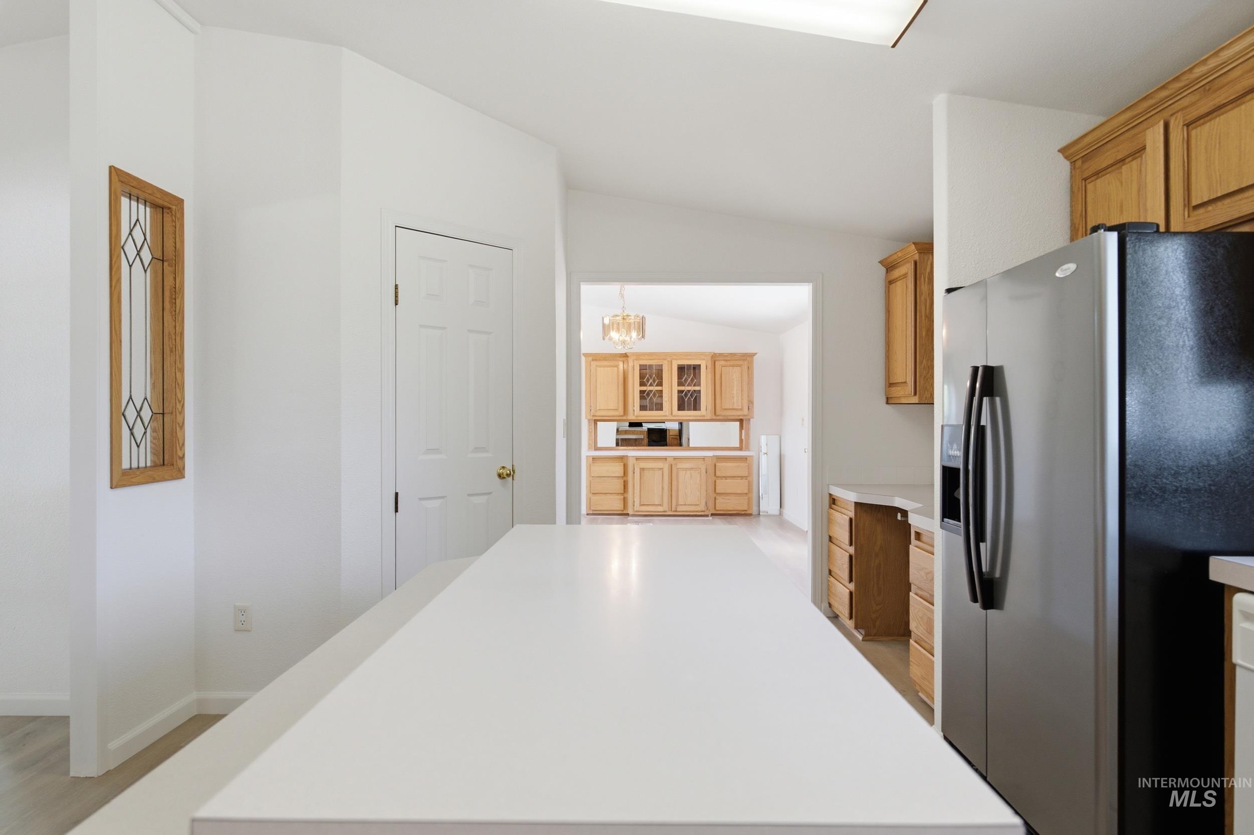 7422 Track Road Nampa, ID 83686 - Photo 12 of 50 Kitchen featuring a large central island with a white countertop, stainless steel refrigerator, and wood cabinetry