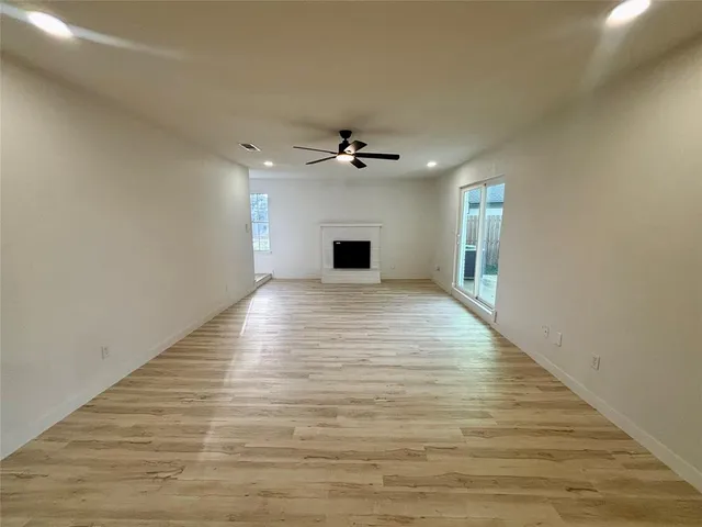 a view of a livingroom with a ceiling fan a fireplace a ceiling fan and wooden floor