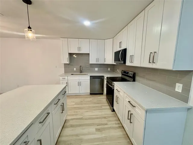 a kitchen with a sink a stove and cabinets
