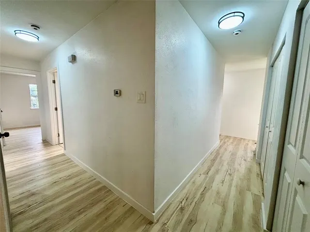 a view of a hallway with wooden floor and staircase