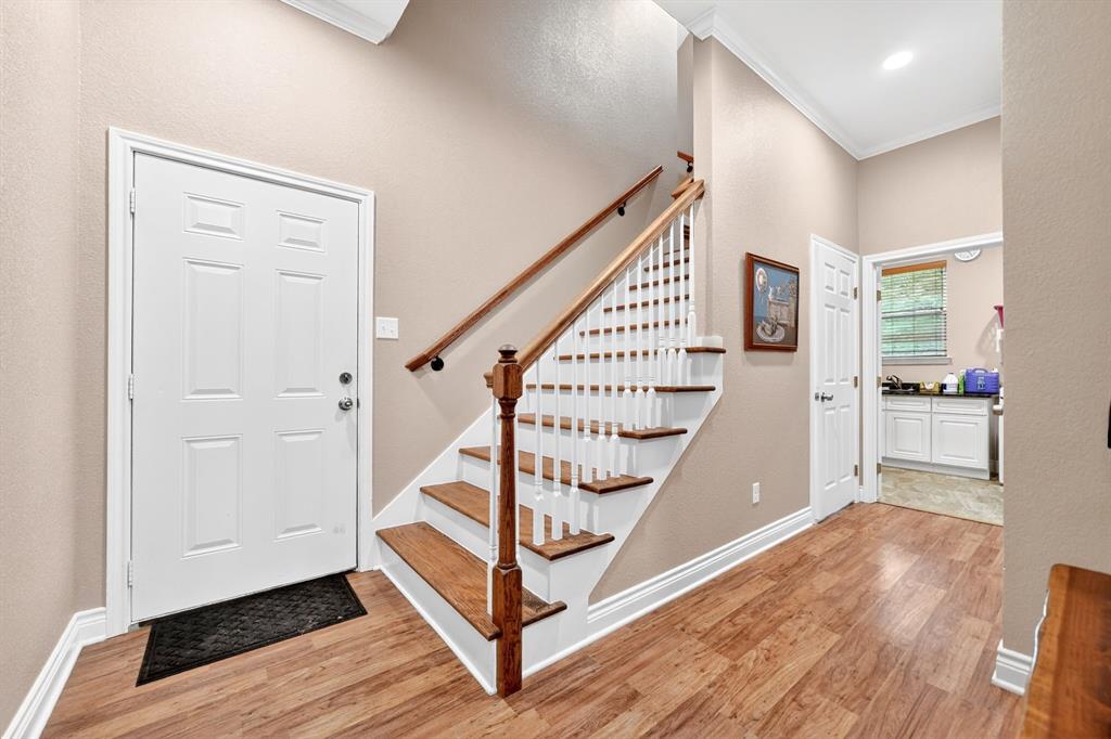 5230 Esquire Estates Road Mabank, TX 75156 - Photo 26 of 39 Entryway featuring wood-finish flooring, a white paneled door, and a staircase with white risers and wood treads