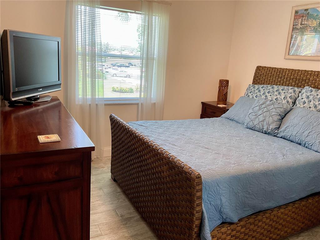3213 South Beneva Road, Unit 204 Sarasota, FL 34232 - Photo 13 of 18 a bedroom with a bed and a flat screen tv