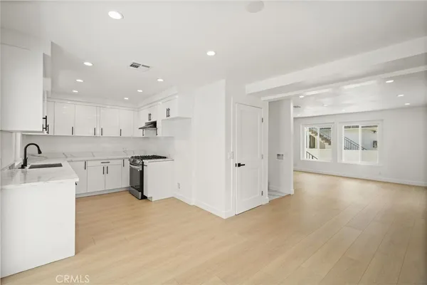 a kitchen with granite countertop white cabinets and white appliances