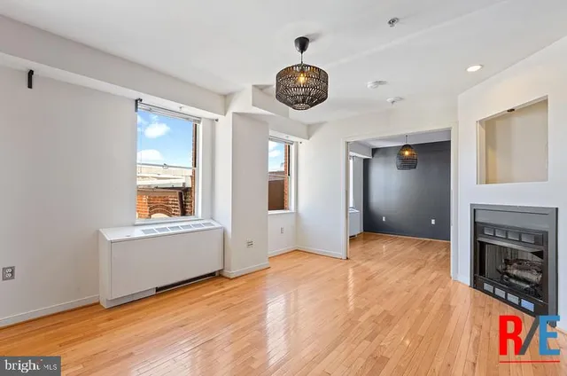 a view of an empty room with a window and fireplace