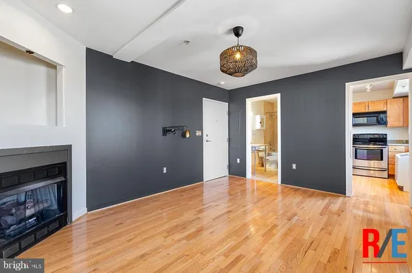 a view of an empty room with window and wooden floor