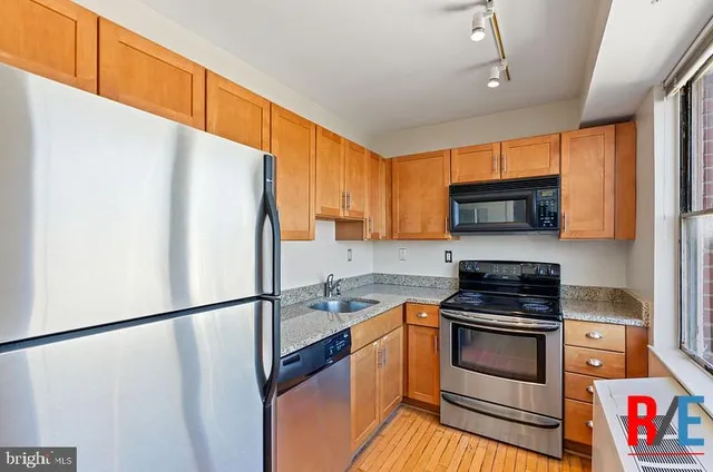 a kitchen with stainless steel appliances a refrigerator sink and microwave