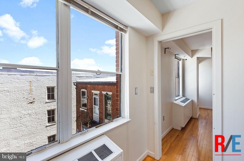 815 King Street, Unit 4C Alexandria, VA 22314 - Photo 9 of 27 a view of an entryway with wooden floor and a floor to ceiling window