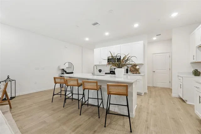 a dining hall with stainless steel appliances granite countertop a table chairs and a refrigerator