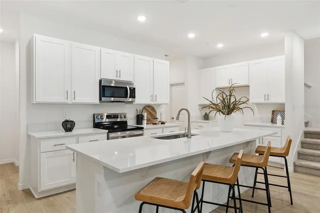 a kitchen with a sink a microwave and cabinets