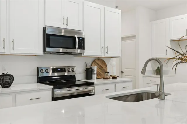 a kitchen with stainless steel appliances granite countertop a sink a stove and a microwave