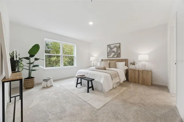 a bedroom with a bed and a large window