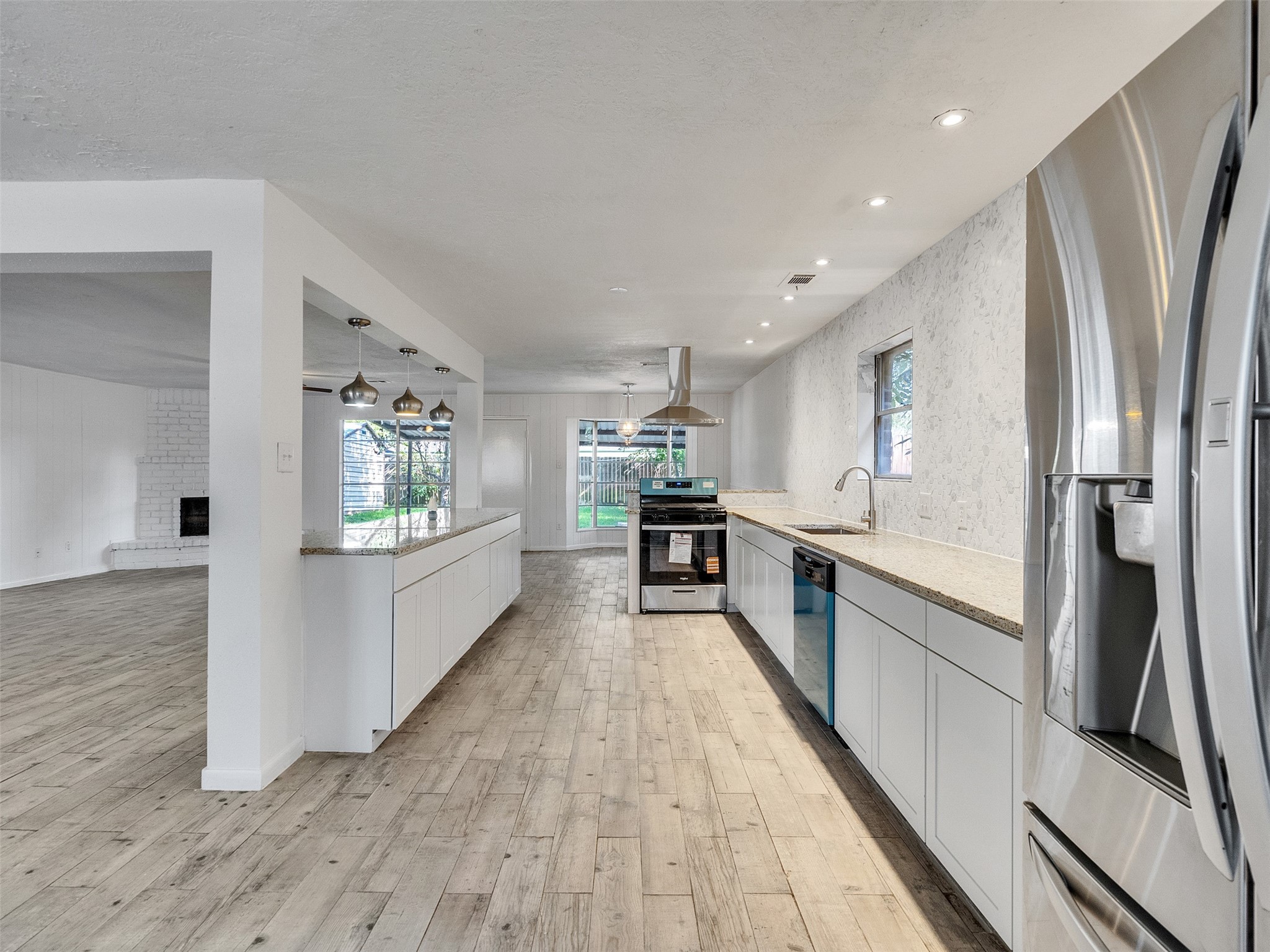 12710 Crow Valley Lane Houston, TX 77099 - Photo 8 of 34 a large kitchen with stainless steel appliances a refrigerator a stove a sink dishwasher a oven with wooden floor and cabinets