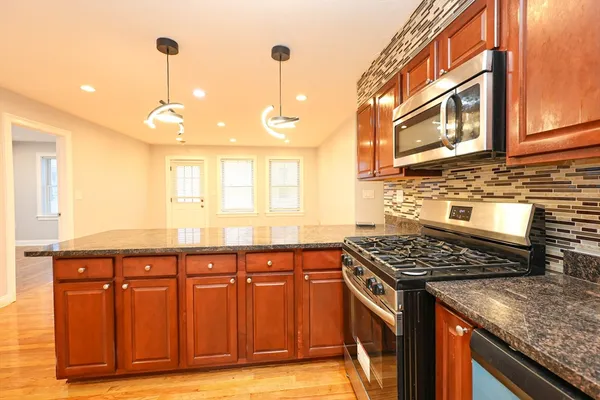 a kitchen filled with stainless steel appliances granite countertop a stove and a sink
