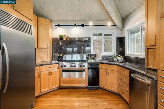 a kitchen with stainless steel appliances granite countertop a stove and a refrigerator