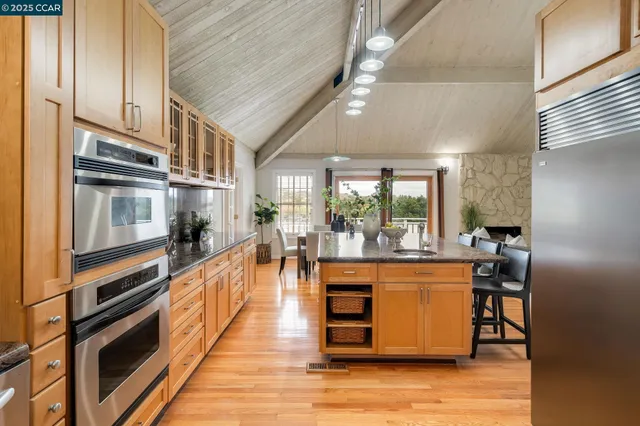 a kitchen with stainless steel appliances granite countertop a refrigerator and a stove