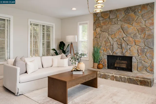 a living room with furniture a fireplace and a chandelier