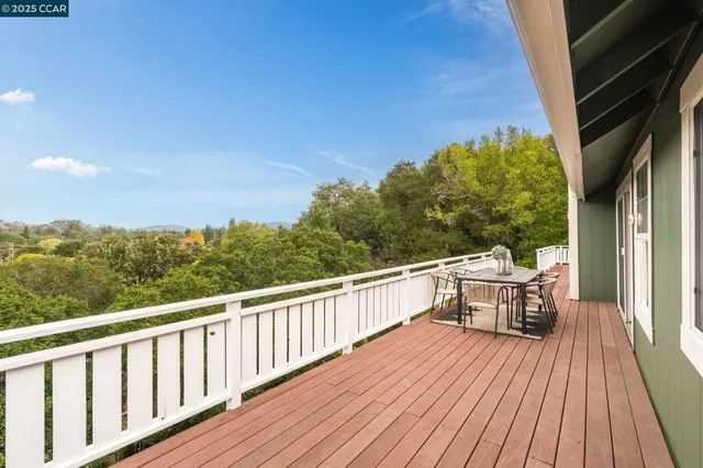a balcony with wooden floor table and chairs
