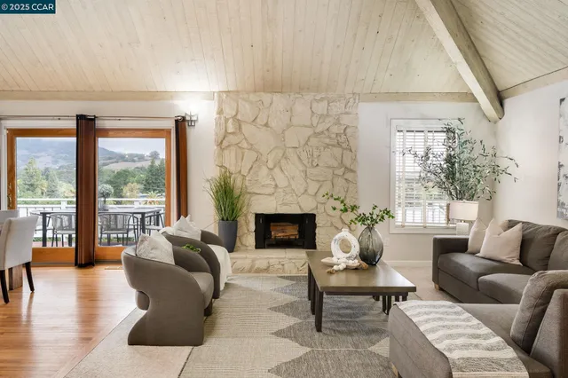 a living room with furniture a fireplace and a table with wooden floor