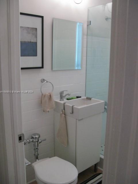 1525 Meridian Avenue, Unit 207 Miami Beach, FL 33139 - Photo 16 of 18 a bathroom with a toilet sink and mirror