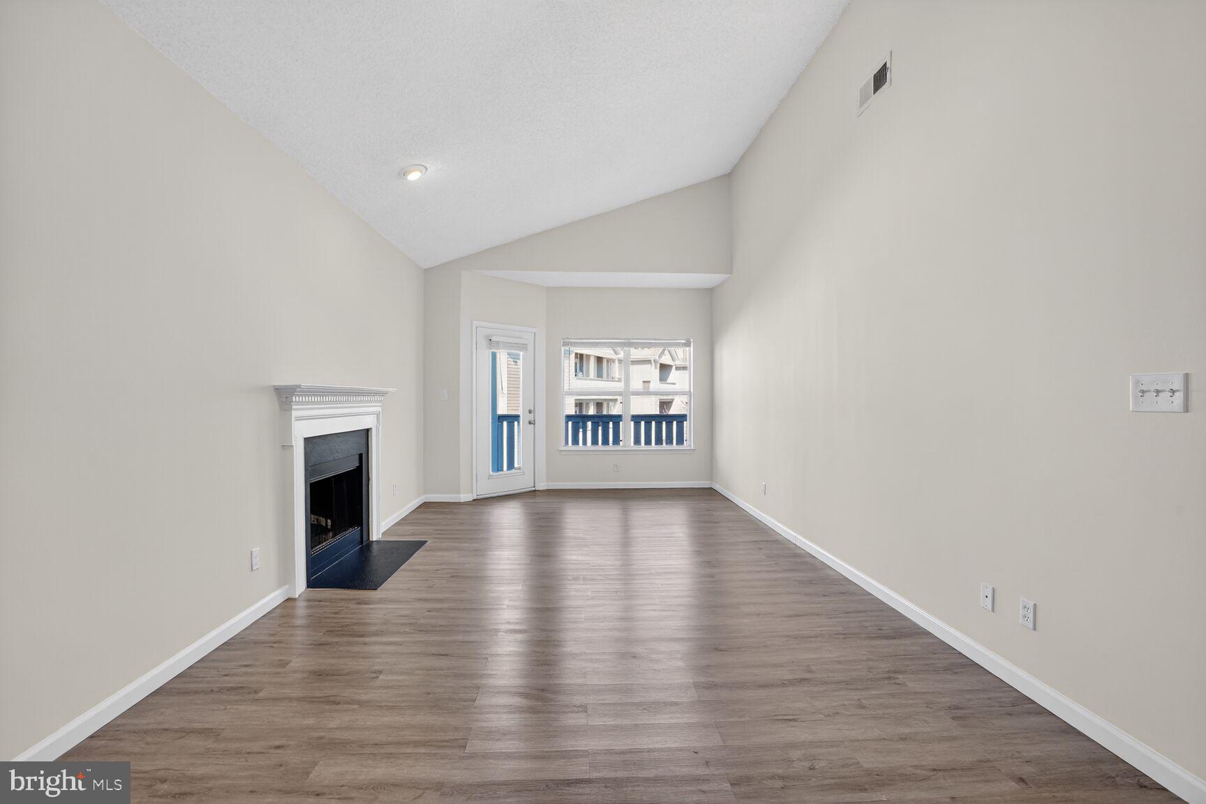 14322 Climbing Rose Way, Unit 306 Centreville, VA 20121 - Photo 6 of 35 a view of an empty room with a fireplace and a window