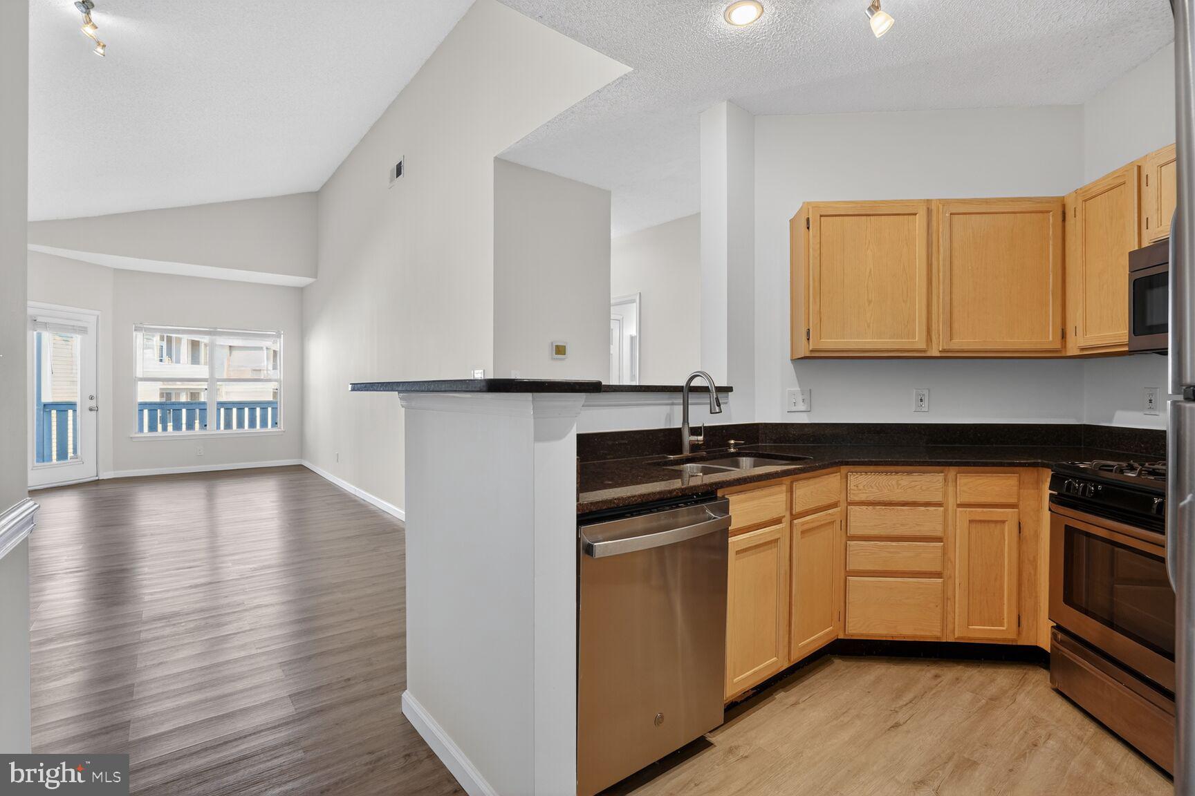 14322 Climbing Rose Way, Unit 306 Centreville, VA 20121 - Photo 9 of 35 a kitchen with granite countertop a stove and a sink