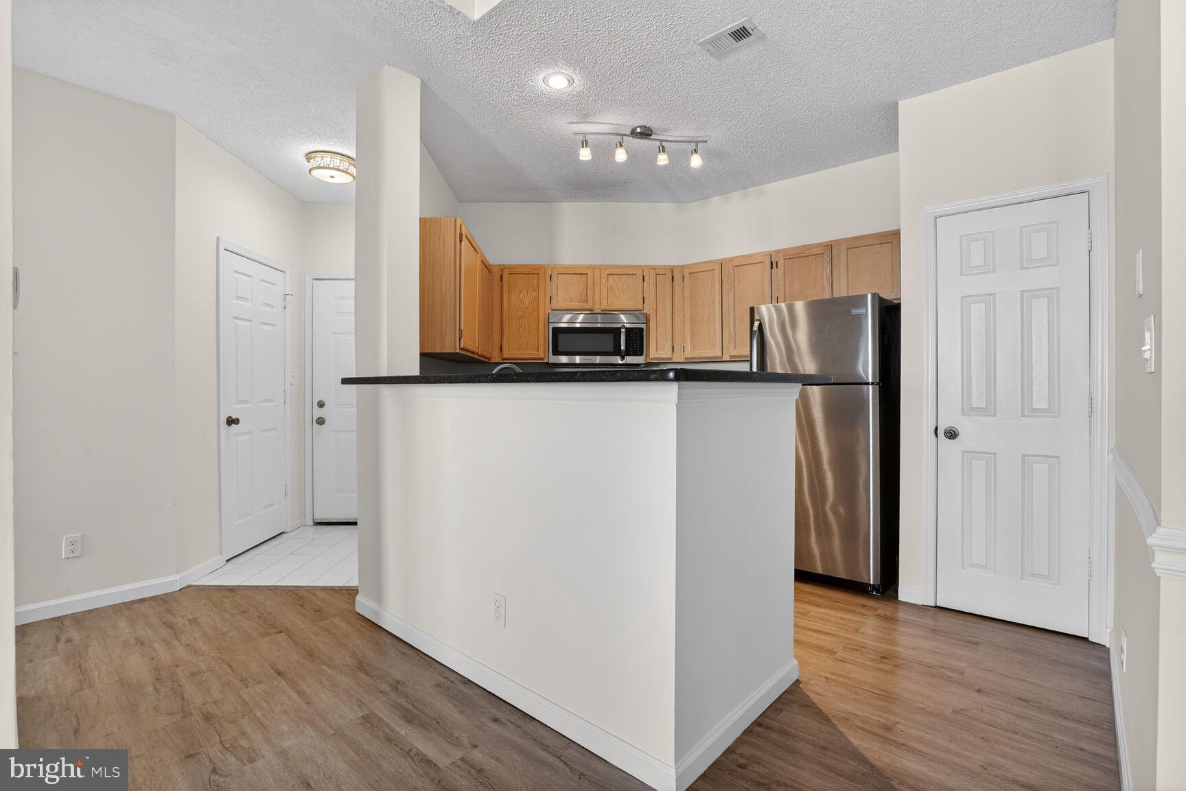 14322 Climbing Rose Way, Unit 306 Centreville, VA 20121 - Photo 10 of 35 a kitchen with stainless steel appliances a refrigerator and a stove top oven