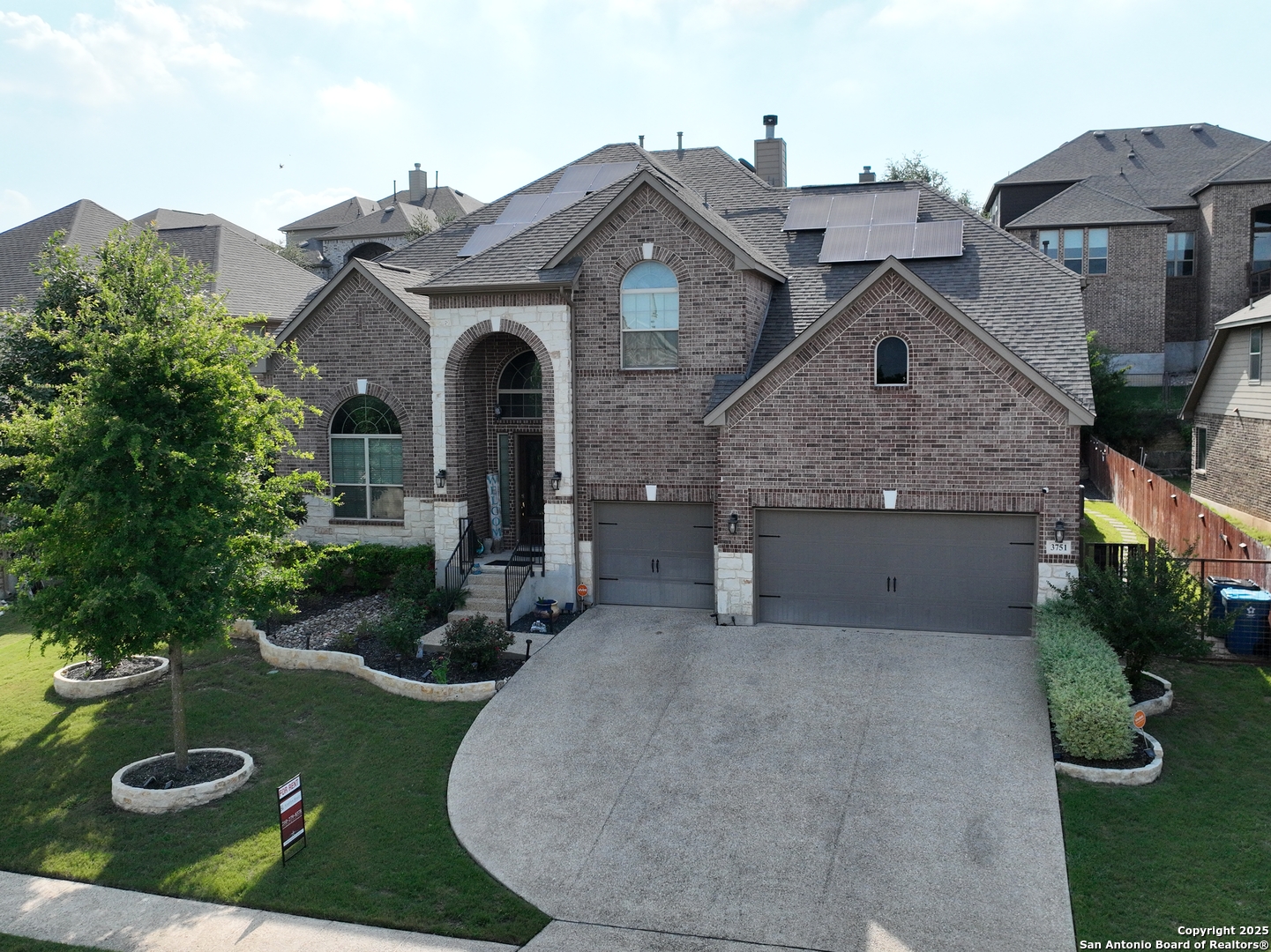 an aerial view of a house with garden space and a street