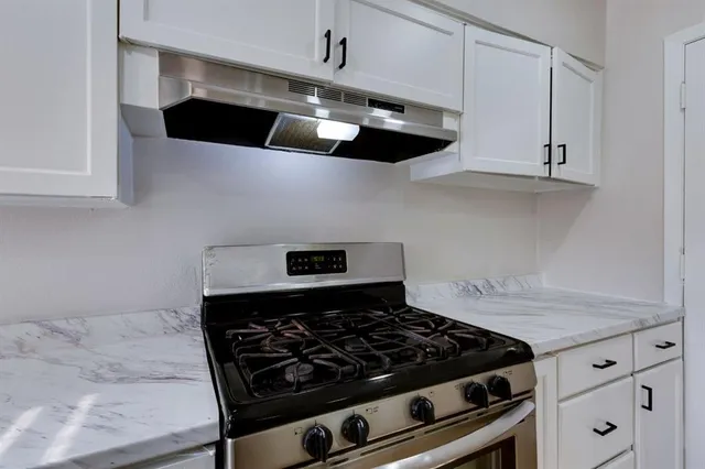 a stove top oven sitting inside of a kitchen