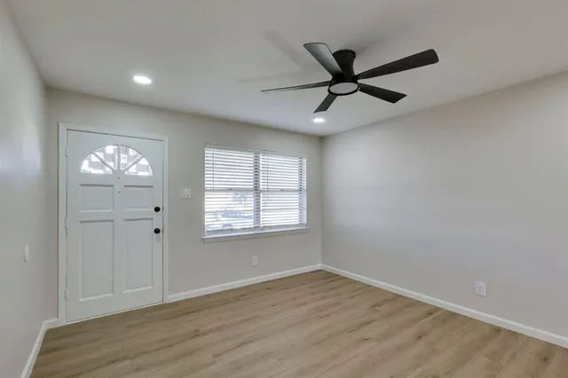 a view of a livingroom with a ceiling fan and wooden floor