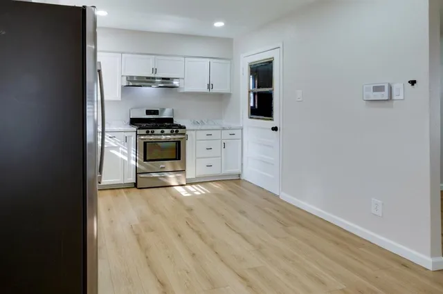 a kitchen with stainless steel appliances a stove top oven and a refrigerator