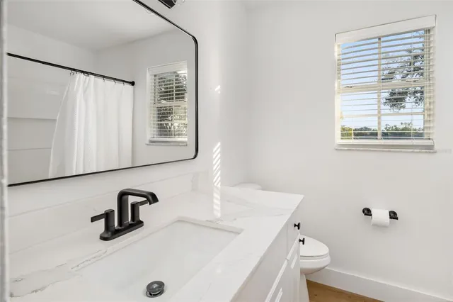 a view of a big house with a big yard and large trees