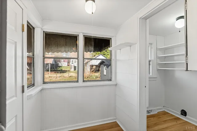 a view of a small space with wooden floor and a window