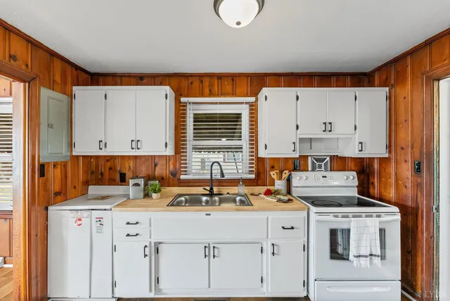a kitchen with cabinets appliances a sink and a window