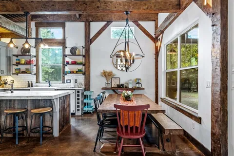 a kitchen with stainless steel appliances granite countertop a dining table and chairs