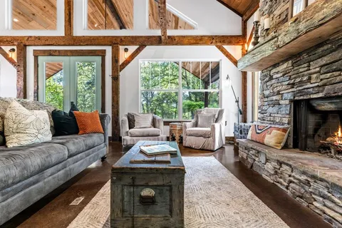 a living room with furniture a rug floor to ceiling windows and a rug