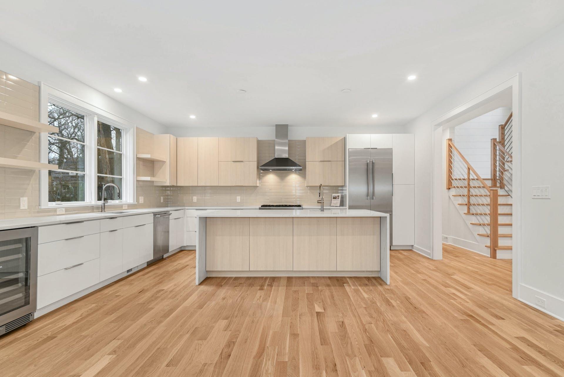 77 Witch Lane Rowayton, CT 06853 - Photo 13 of 39 a large kitchen with kitchen island wooden floors white cabinets and stainless steel appliances