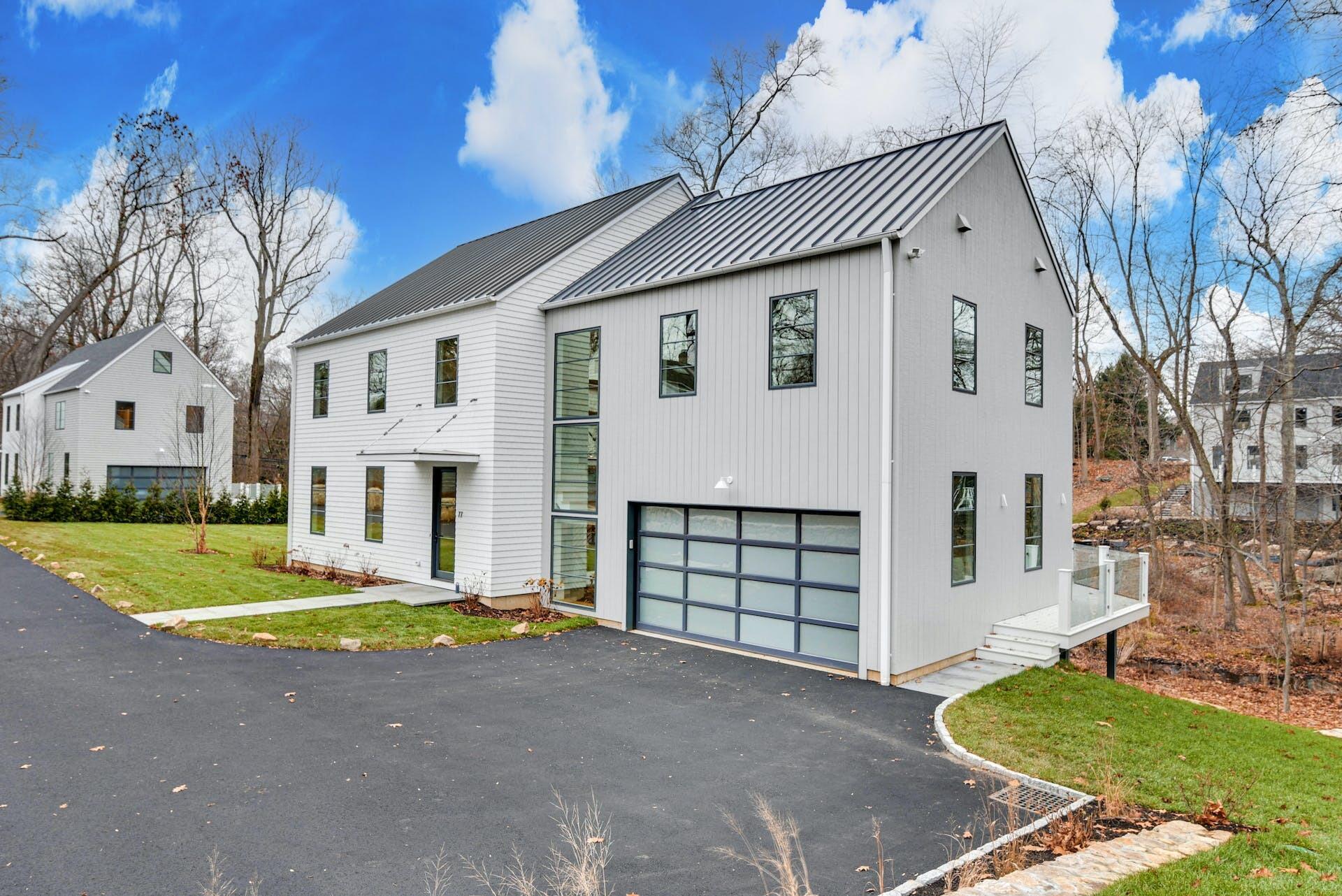 77 Witch Lane Rowayton, CT 06853 - Photo 2 of 39 a front view of a house with a yard and garage