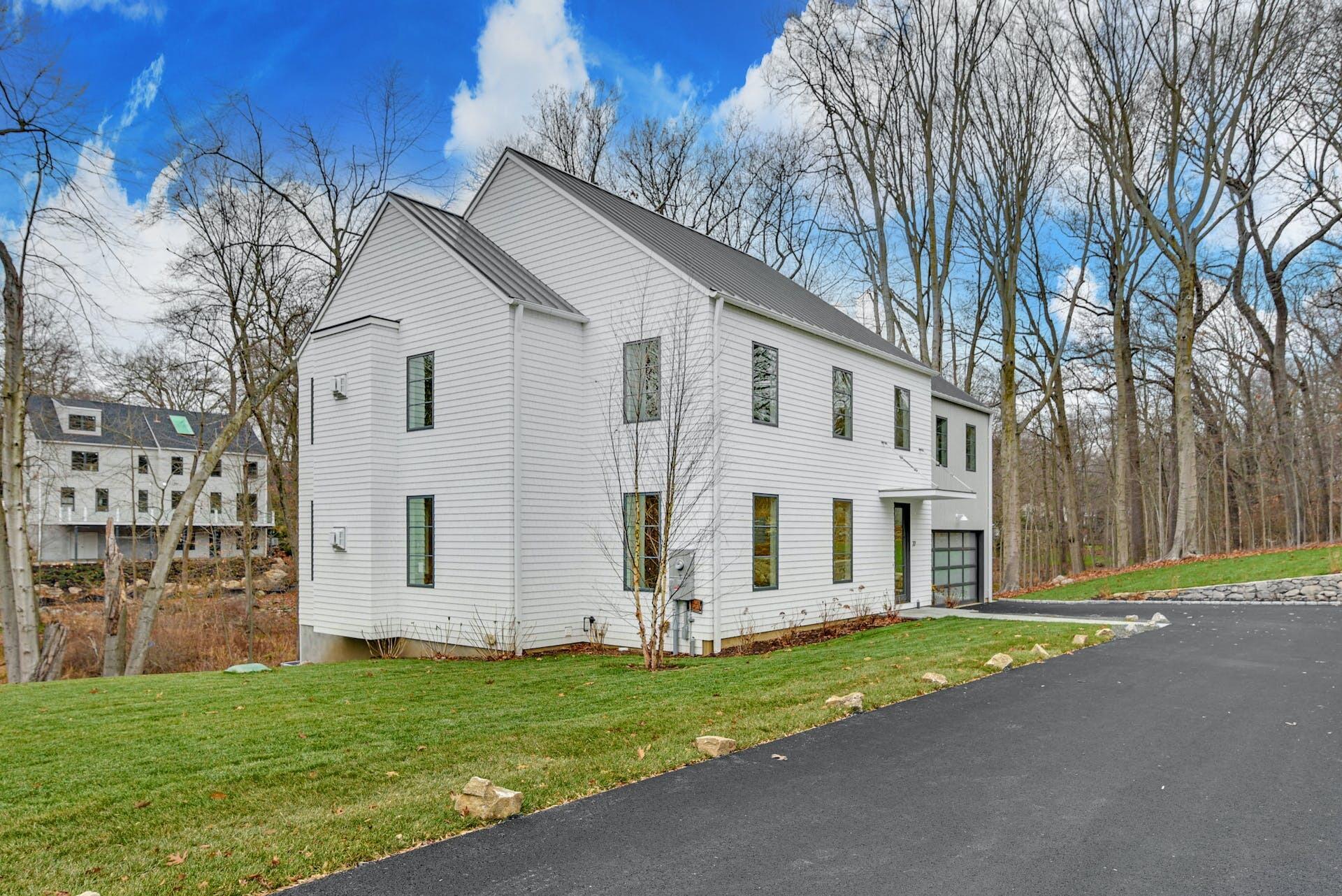 77 Witch Lane Rowayton, CT 06853 - Photo 3 of 39 a view of a white house with a big yard and large trees