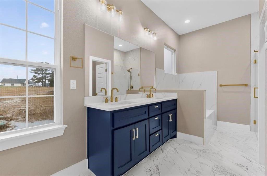 335 Cross Tie Ranch Road Trinidad, TX 75163 - Photo 22 of 30 Dual vanity with a white countertop and gold-tone fixtures, deep blue cabinetry, and a full-width mirror