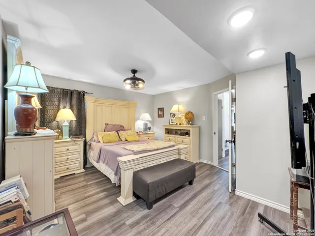a large white room with kitchen island a flat screen tv and a refrigerator