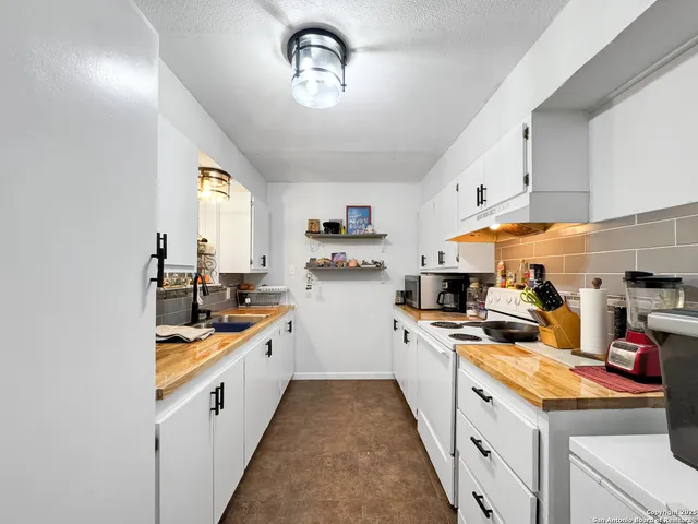 a kitchen with a sink a stove and cabinets