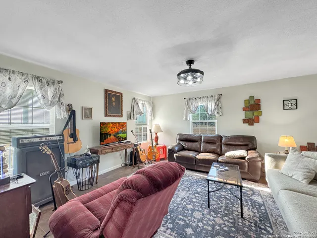 a living room with furniture kitchen view and a window