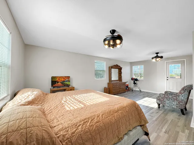 a spacious bedroom with a bed and a chandelier