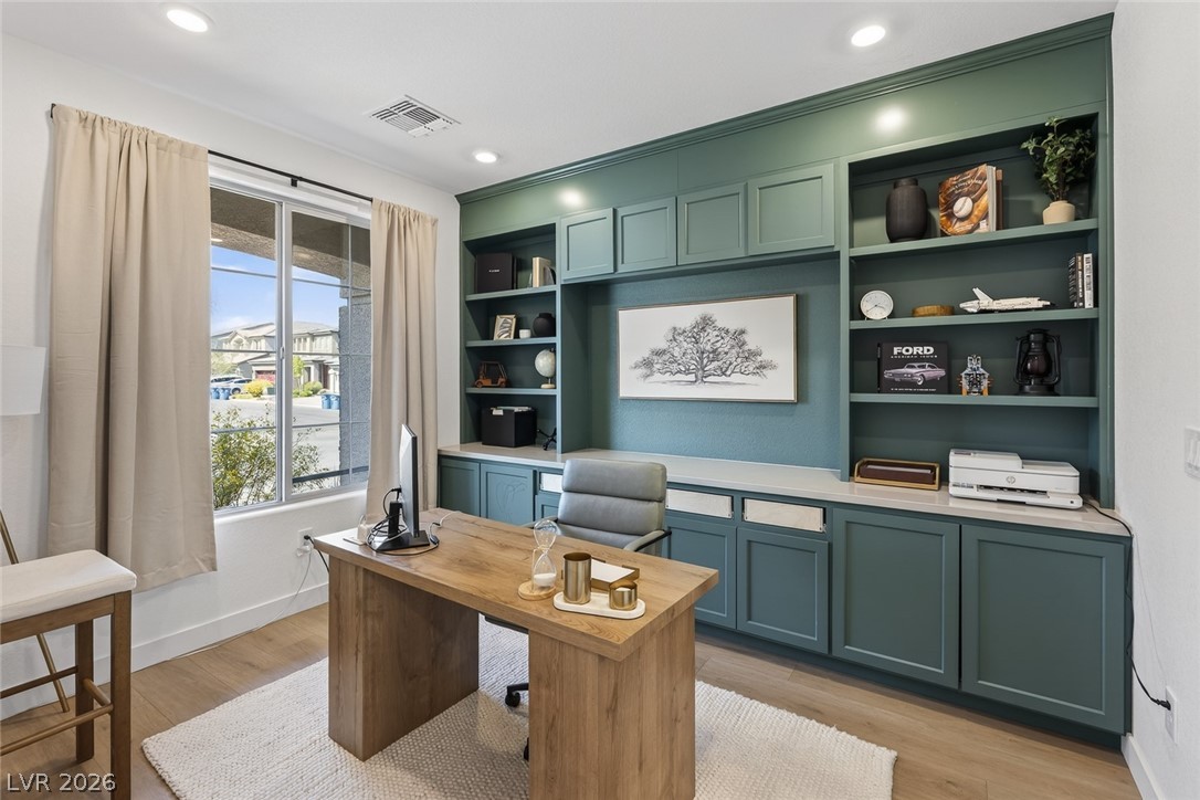 10446 Emerald Rye Street Las Vegas, NV 89183 - Photo 4 of 37 An inviting home office boasts custom built-in cabinetry and ample natural light, perfect for productivity.