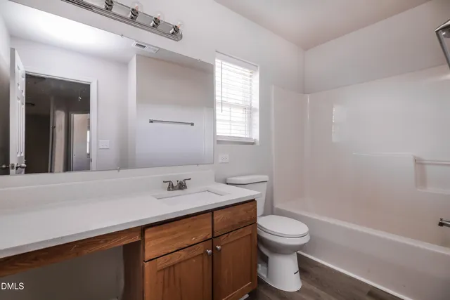 a bathroom with a sink toilet vanity and tub