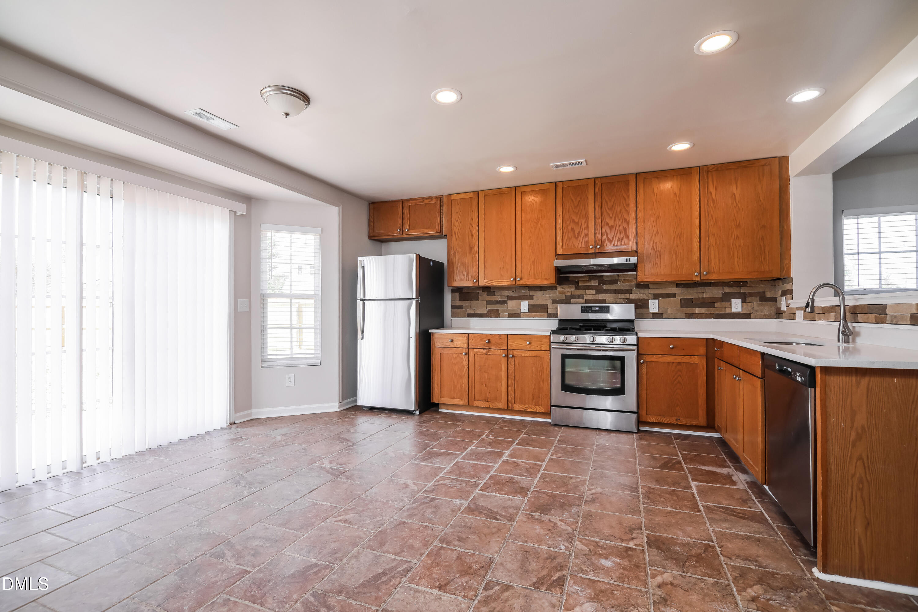 3716 Tryon Ridge Drive Raleigh, NC 27610 - Photo 5 of 17 a kitchen with stainless steel appliances granite countertop a stove a sink dishwasher a refrigerator and cabinets with wooden floor
