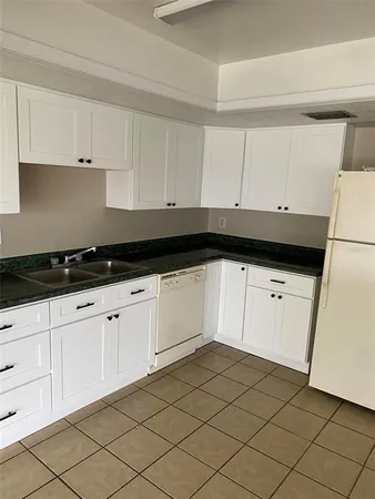 a kitchen with white cabinets and white appliances